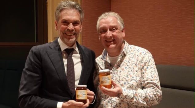 Pim Lemmers holding a jar of his own honey